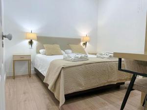 a bedroom with a bed with two lamps on it at Cayres Suites Surdo in Funchal