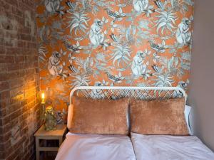 een slaapkamer met een bed met een oranje muur bij Urban Jungle! in Berlijn