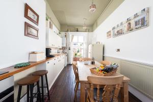 a kitchen with a table and chairs and a refrigerator at Stunning & spacious Georgian town house in St Neots town centre with parking in Saint Neots