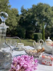 una mesa con un jarrón de cristal y un tazón de flores en VIENIACASACCADIA, en Accadia