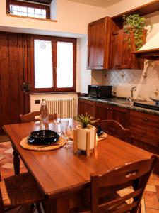 une cuisine avec une table en bois et des chaises ainsi qu'une salle à manger dans l'établissement CASA ARMANNI - la tua Casa di Pietra, à Gubbio