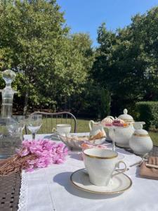 una mesa con tazas de té y cuencos en ella en VIENIACASACCADIA, en Accadia