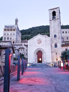 una grande chiesa bianca con una torre e un orologio di CASA ARMANNI - la tua Casa di Pietra a Gubbio