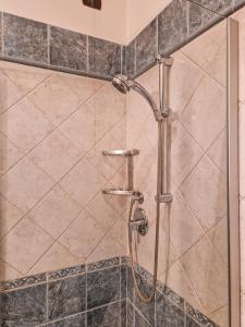 La salle de bains est pourvue d'une douche avec une porte en verre. dans l'établissement CASA ARMANNI - la tua Casa di Pietra, à Gubbio