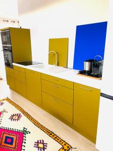 a kitchen with yellow cabinets and a sink at Le loft design st Armand in Salles