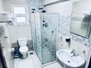 een badkamer met een douche, een toilet en een wastafel bij Casa Do Cairo - Rehab City in Caïro