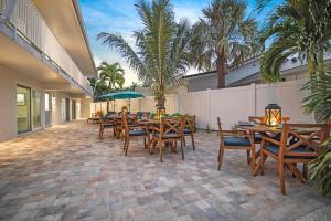 een patio met houten tafels en stoelen en palmbomen bij The Coral Reef - L in Siesta Key