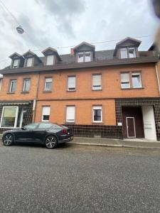 a car parked in front of a brick building at Annie´s Appartements in Mannheim