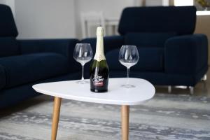 a bottle of wine on a table with two wine glasses at Noa Apartments in Vlorë