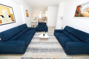 ein Wohnzimmer mit 2 blauen Sofas und einem Tisch in der Unterkunft Noa Apartments in Vlorë