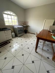 a kitchen with a table and a tiled floor at Hospedaria Chaves in Brasília