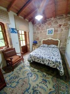a bedroom with a bed and a stone wall at Charming villa in Riveira with private pool 260 m² in Ribeira