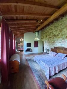 a bedroom with a bed and a stone wall at Charming villa in Riveira with private pool 260 m² in Ribeira