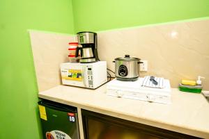 a kitchen with a microwave and a coffee maker on a counter at Apartamento Aliga 2 in Quepos