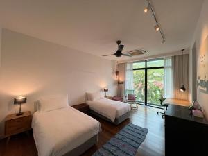 a bedroom with two beds and a ceiling fan at Malibu Langkawi Private Pool Villa in Pantai Cenang +42 photos