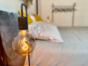 a light bulb with a dollar sign in it next to a bed at Malpensa Home Milan Lakes in Case Nuove