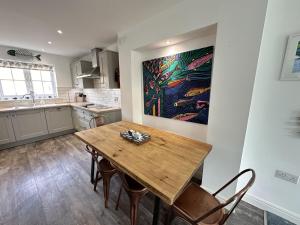 a kitchen with a wooden table and chairs at The Tidal Shack - Part of the The Bay Filey Holiday Village with pool, gym and direct beach access, pub, restaurant, tennis and meadows walks in Reighton