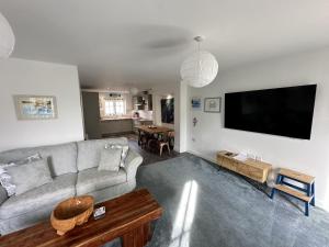 a living room with a couch and a flat screen tv at The Tidal Shack - Part of the The Bay Filey Holiday Village with pool, gym and direct beach access, pub, restaurant, tennis and meadows walks in Reighton
