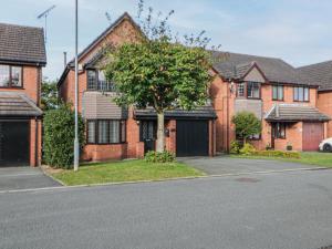 a house with a tree in front of a street at The Croft, North Staffordshire in Stoke on Trent
