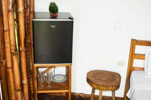 um frigorífico num quarto com uma mesa e uma cadeira em ECO-POR em Rio do Ouro