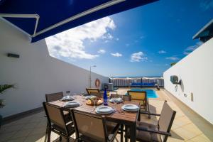 a dining room with a table and chairs on a balcony at Jasmin in Puerto Calero