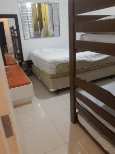een slaapkamer met 2 stapelbedden en een spiegel bij Casa com estacionamento coberto, localizada em Vila Sahy in São Sebastião