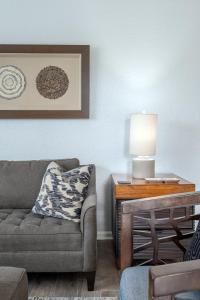 een woonkamer met een bank en een tafel met een lamp bij La Vista Lakeview Condo in Orlando