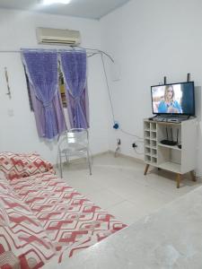 a bedroom with a bed and a tv on a table at Casa com estacionamento coberto, localizada em Vila Sahy in São Sebastião