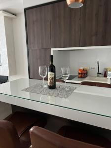 茲拉蒂博爾的住宿－NUMBER ONE ZLATIBOR，一瓶葡萄酒和两杯酒杯坐在柜台上