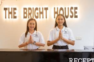 Dwie dziewczyny stoją przed stołem z rękami w ręce. w obiekcie The Bright House, Koh Phi Phi w Ko Phi Phi