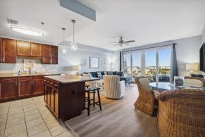 a kitchen and living room with a table and chairs at Laketown Wharf #317 by Nautical Properties in Panama City Beach