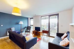 een woonkamer met een bank en een tv bij Appealing 2 Bedroom apartment in Bethnal Green in Londen
