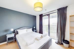 a bedroom with a bed and a large window at Appealing 2 Bedroom apartment in Bethnal Green in London