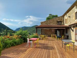 a wooden deck with tables and chairs on a building at Auberge de Miélandre in Teyssières