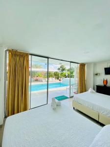 ein Schlafzimmer mit einem großen Bett und einem Pool in der Unterkunft Hotel West California in Armenia
