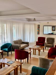 een woonkamer met banken, stoelen en tafels bij The Address Resort in Kalangala