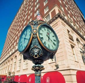 un orologio su un palo di fronte a un edificio di The Brown Hotel a Louisville