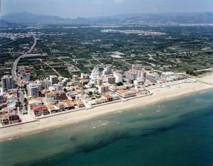 eine Luftansicht auf einen Strand mit Gebäuden und das Meer in der Unterkunft Apartamento a 100 metros del mar in Piles