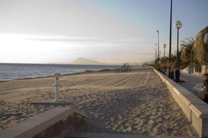 einen Sandstrand mit Meerblick in der Unterkunft Apartamento a 100 metros del mar in Piles
