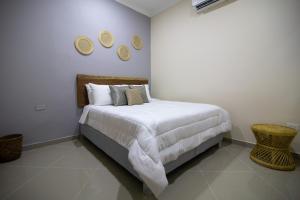 1 dormitorio con 1 cama y 3 platos en la pared en Casa Palmar Cartagena, en Cartagena de Indias