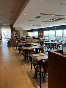 un comedor con mesas y sillas en un restaurante en Flat Luxo Fusion SHN - Melhor Localização de BSB, en Brasilia