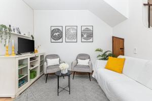 ein Wohnzimmer mit einem weißen Sofa und 2 Stühlen in der Unterkunft Casa Gaivota by Algarve Golden Properties in Lagos