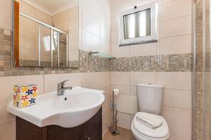 a bathroom with a sink and a toilet and a mirror at Casa Gaivota by Algarve Golden Properties in Lagos +15 photos