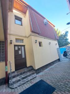 a house with a black door and some stairs at Penthouse Daniela - 3 Rooms in a Spacious Central Apartment in Târgu-Mureş