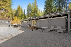 a home with a patio and a building with trees at Pinecone Den in Leavenworth