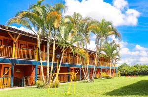 a building with palm trees in front of it at Hotel Quindio Campestre in Montenegro