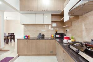 a kitchen with wooden cabinets and a counter top at Kolam Serviced Apartments - Adyar. in Chennai