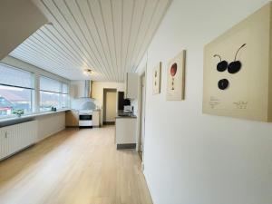 cocina grande con paredes blancas y suelo de madera en aday - Modern 3 bedrooms apartment in Svenstrup, en Svenstrup