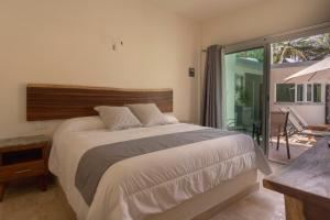 - une chambre avec un grand lit et un balcon dans l'établissement PETRAS HOTEL, à Brisas de Zicatela