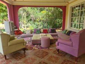 a living room with a couch and two chairs at Botanical Garden 